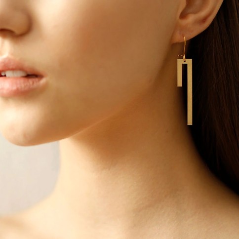 Boucles d'oreilles pendantes - Linear A FUTURE PERFECT portées par une femme