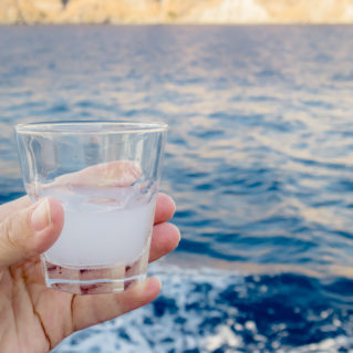 Ver d'ouzo face à la mer en Grèce