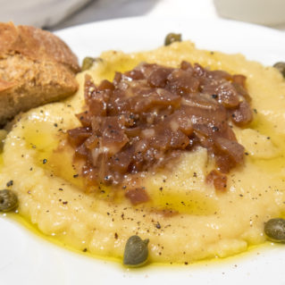 La fava, un plat inoubliable de la cuisine grecque servie comme mezze avec des câpres et d'oignons caramélisés