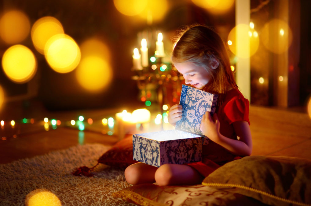 Une fille qui ouvre son cadeau de Noël ou Nouvel An