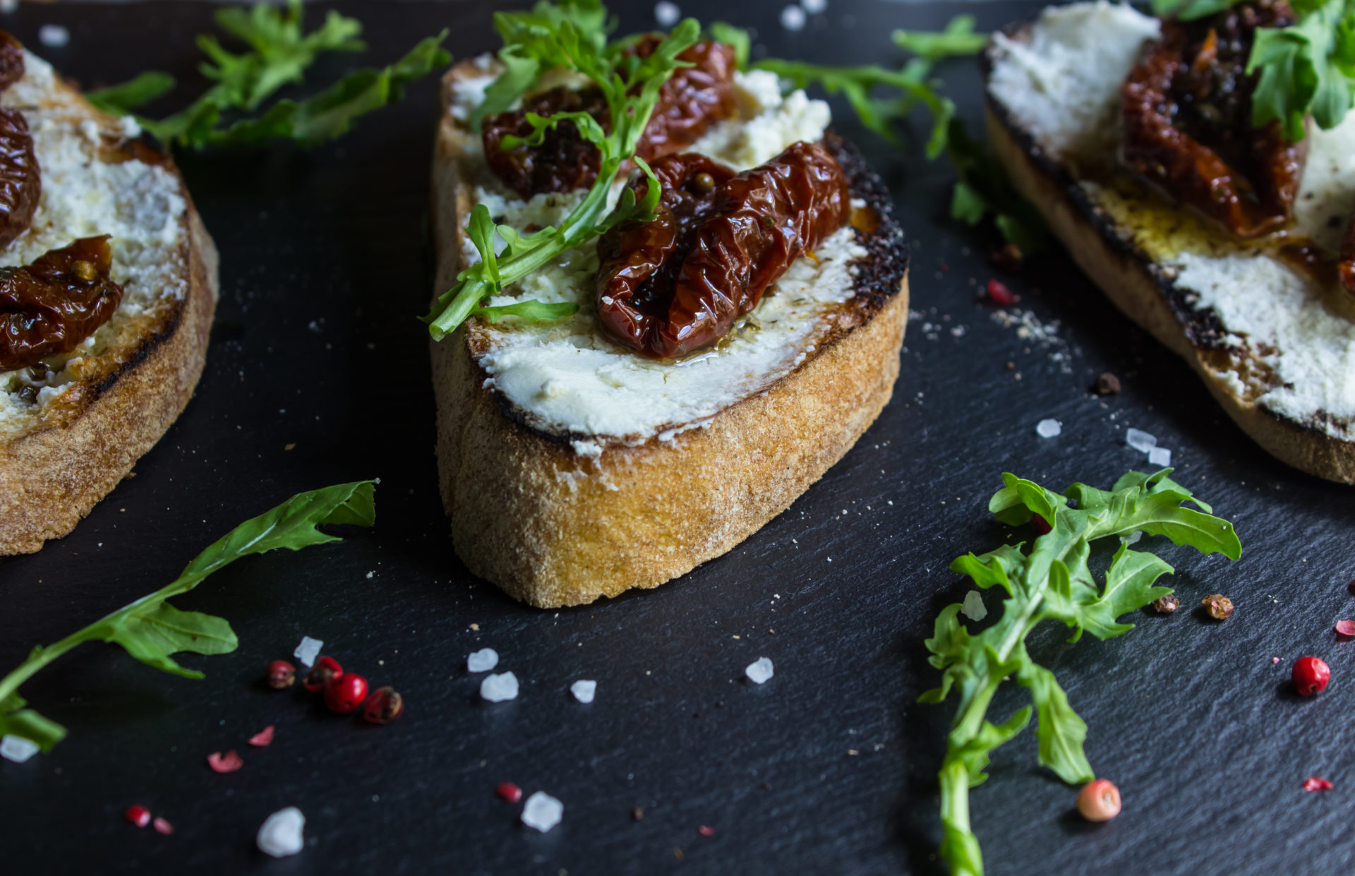 Bruschetta with fresh cheese, sun-dried tomatoes and thyme