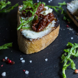 Bruschetta with fresh cheese, sun-dried tomatoes and thyme